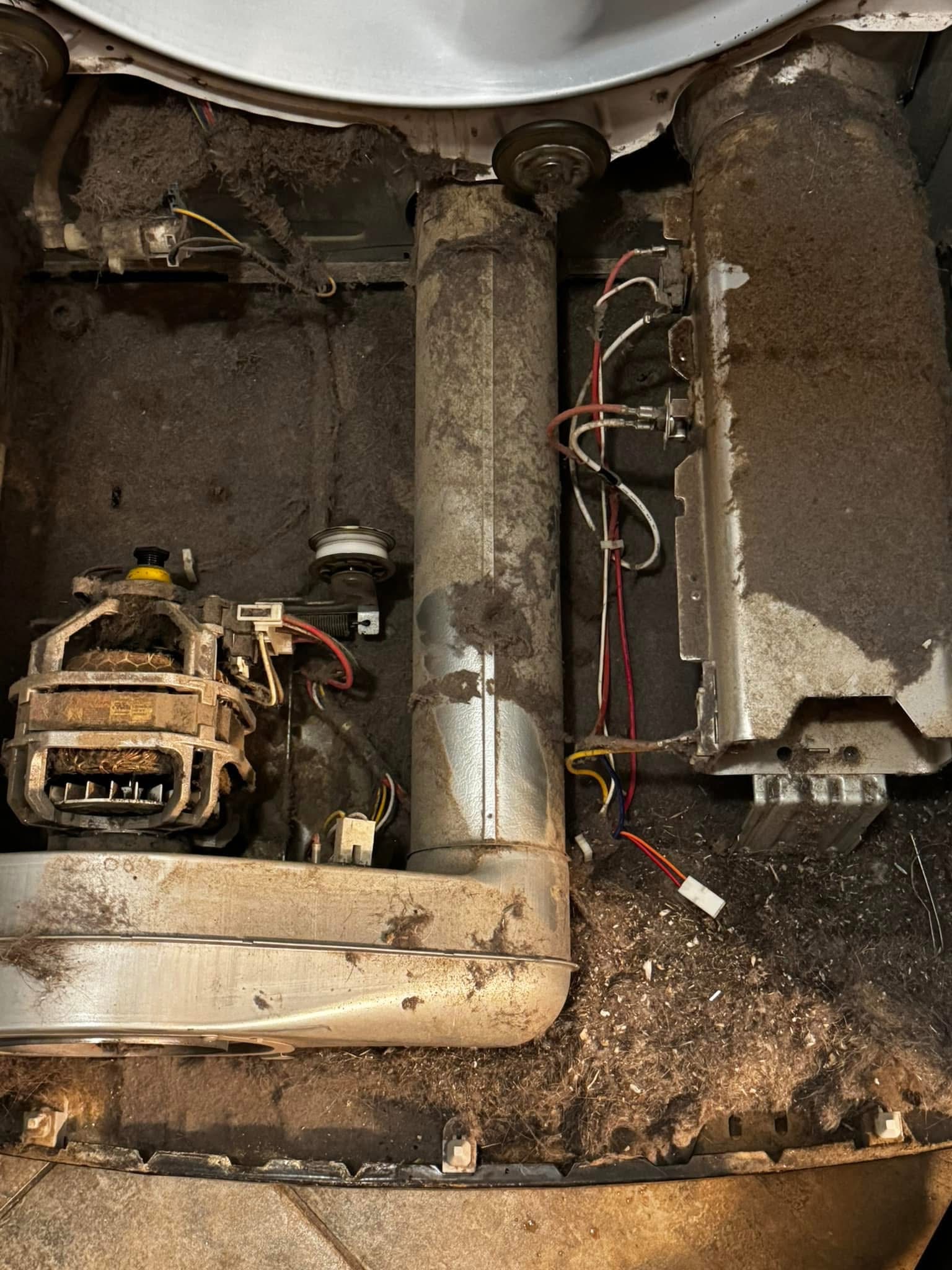 Heavy lint buildup inside an opened dryer before cleaning